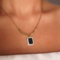 Close-up of black pendant on gold plated necklace