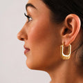 woman wearing nova gold earrings