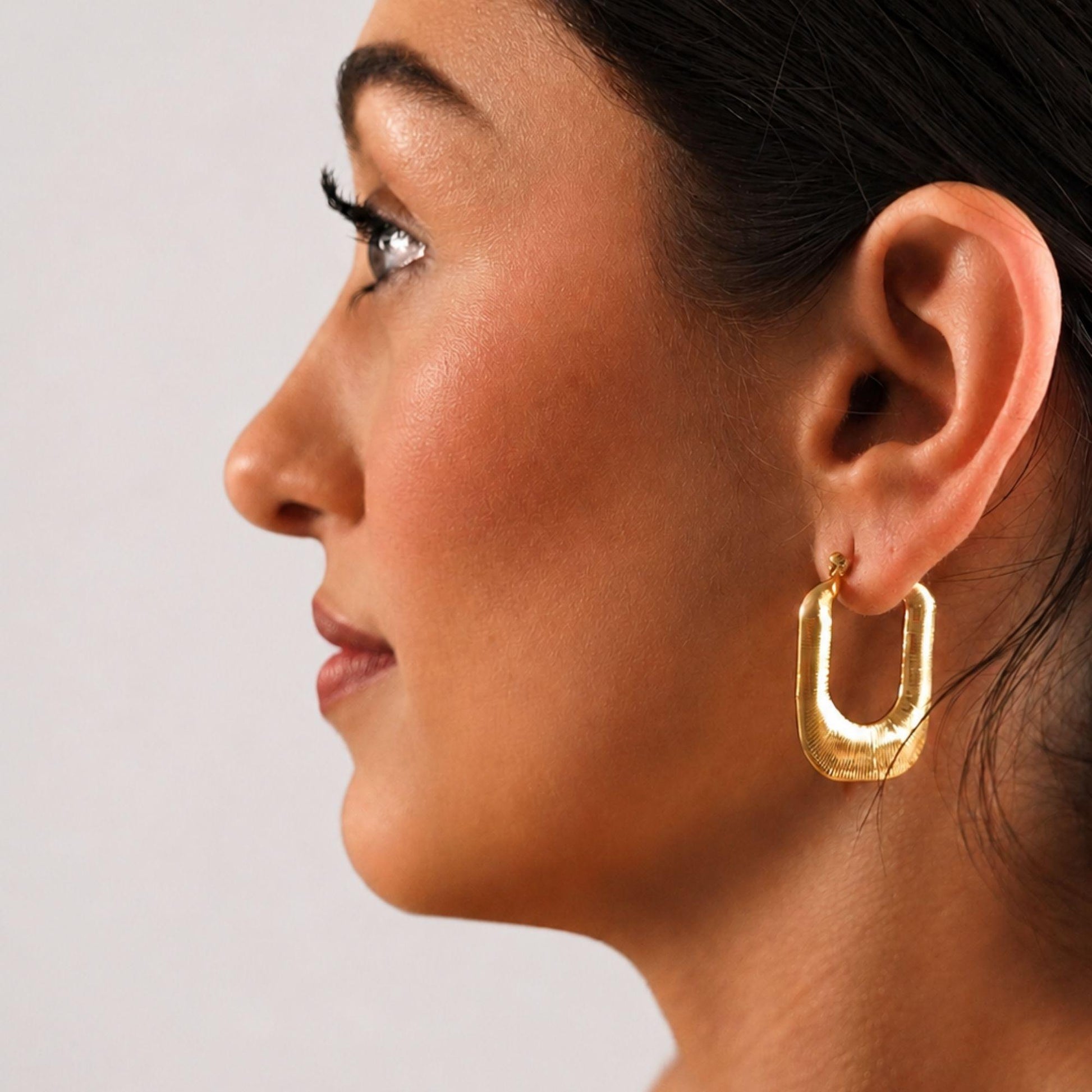 woman wearing nova gold earrings