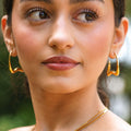 Vela gold sculptural earring worn on ear