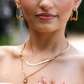Side view of Vela gold stainless steel sculptural earrings